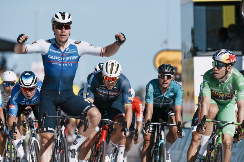 Stage winner Netherlands' Fabio Jakobsen, left, crosses the finish line ahead of Belgium's Wout Van Aert, wearing the best sprinter's green jersey, right and second place, and Denmark's Mads Pedersen, center and third place, during the second stage of the Tour de France cycling race over 202.5 kilometers (125.8 miles) with start in Roskilde and finish in Nyborg, Denmark, Saturday, July 2, 2022. (AP Photo/Thibault Camus)