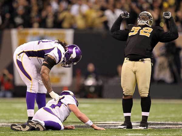 Phil Loadholt checks on teammate Brett Favre after he was hit by Remi Ayodele of the New Orleans Saints during the NFC Championship Game.