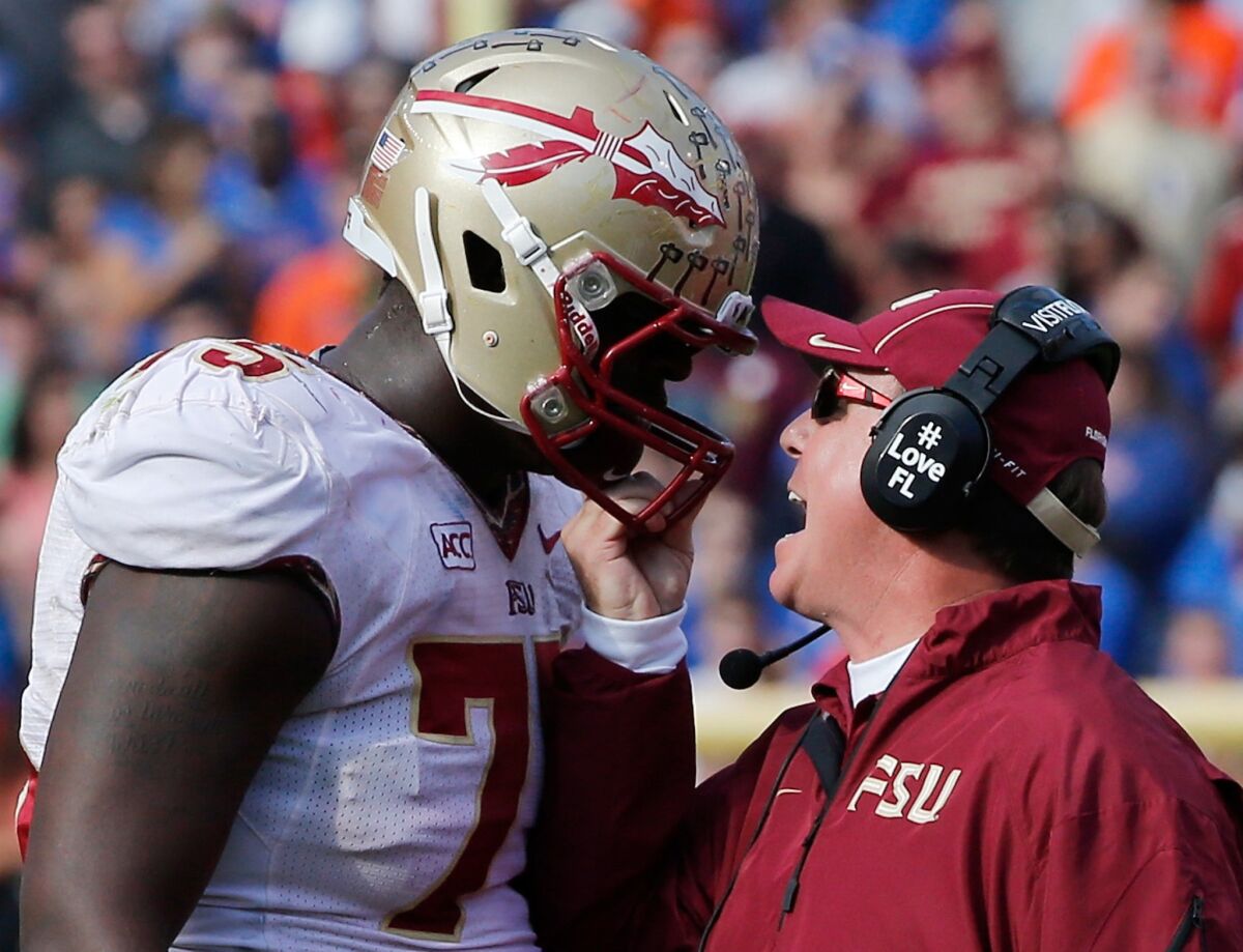 Florida State Coach Jimbo Fisher grabs the helmet of offensive lineman Cameron Erving during a game against Florida on November 30, 2013.