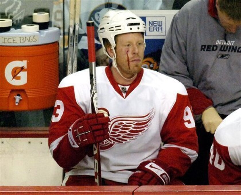 Detroit Red Wings right winger Johan Franzen, of Sweden, sits on the bench after being struck in the face during the first period of an NHL hockey game against the Buffalo Sabres in Buffalo, N.Y. on Monday, April 6, 2009. (AP Photo/Don Heupel)