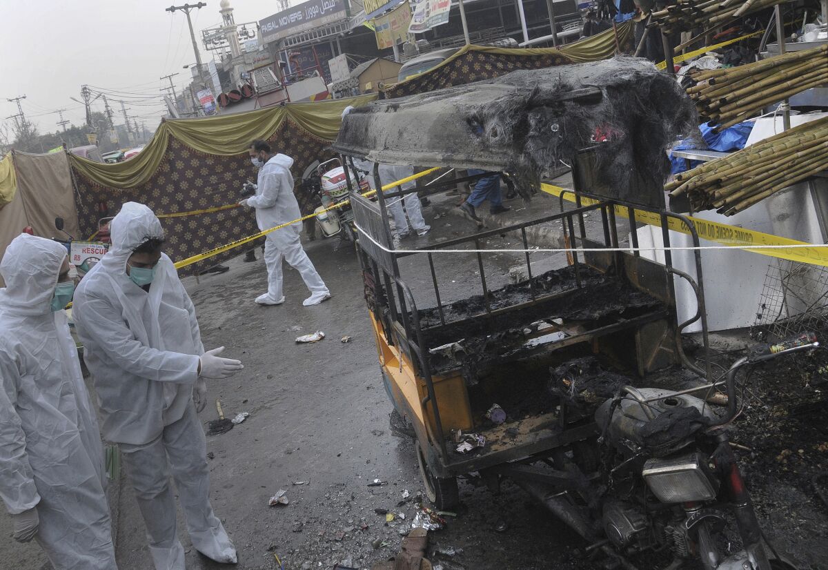 Pakistani investigators examine the site of bomb explosion in Rawalpindi, Pakistan, Friday, Dec. 4, 2020. A roadside bomb exploded near a busy bus terminal in the Pakistani garrison city of Rawalpindi, killing and and wounding some persons, police said. (AP Photo/A.H. Chaudary)
