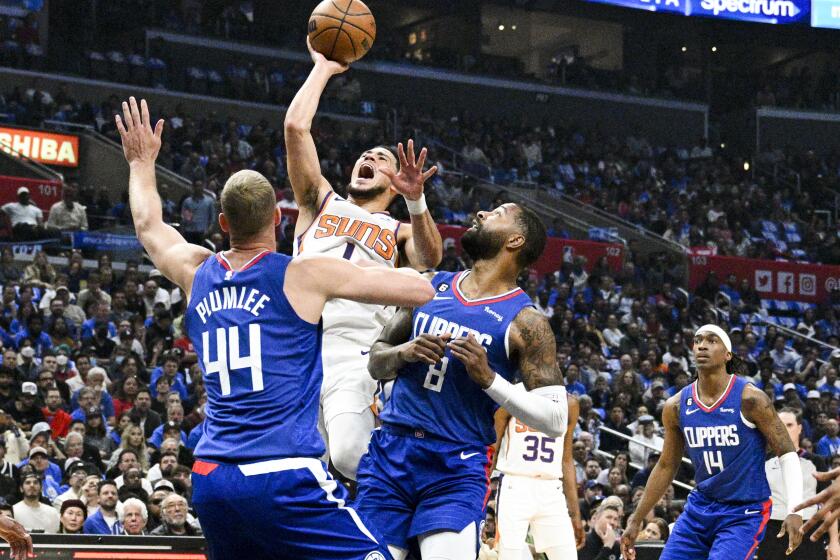 Los Angeles, CA - April 20: Phoenix Suns guard Devin Booker (1) goes up for a shot in front of LA Clippers forward Marcus Morris Sr. (8) and center Mason Plumlee (44) during the first half at Crypto.com Arena on Thursday, April 20, 2023 in Los Angeles, CA.(Gina Ferazzi / Los Angeles Times)