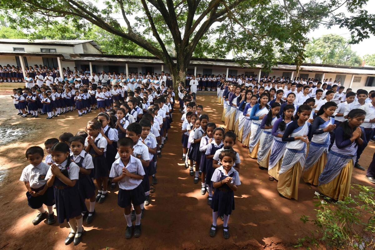 In this photograph taken on June 1, 2016, Indian schoolchildren take part in morning prayers at Rashtriya Swayamsevak Sangh-run Sankardev Sishu Nikatan School in the Betkuchi area of Guwahati.