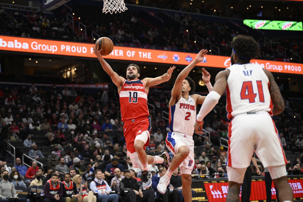 Washington Wizards guard Raul Neto (19) goes to the basket past Detroit Pistons guard Cade Cunningham (2) as forward Saddiq Bey (41) watches during the first half of an NBA basketball game, Tuesday, March 1, 2022, in Washington. (AP Photo/Nick Wass)