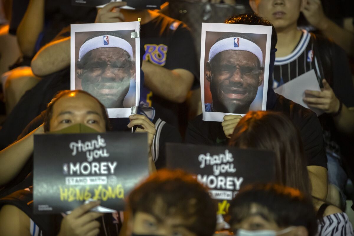 Demonstrators hold up photos of LeBron James grimacing during a rally in Hong Kong on Oct. 15.