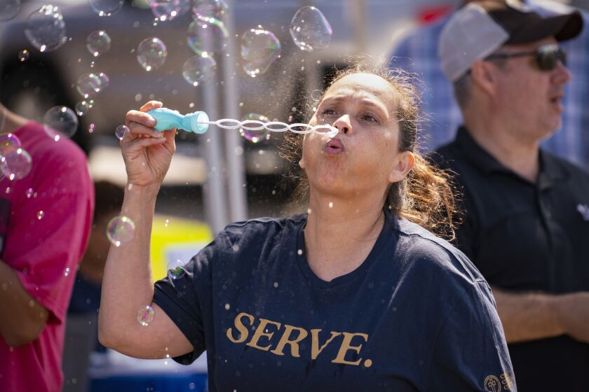SAN DIEGO, CA - OCTOBER 1: Rose Thompson blows bubbles at the Christ Community Church booth during the Mira Mesa Street Fair Saturday October 1, 2022. (Howard Lipin / For The San Diego Union-Tribune)