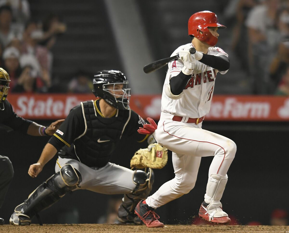 ANAHEIM, CA - AUGUST 13: Shohei Ohtani #17 of the Los Angeles Angels of Anaheim gets a hit while Jacob Stallings #58 of the Pittsburgh Pirates looks on in the ninth inning at Angel Stadium of Anaheim on August 13, 2019 in Anaheim, California. (Photo by John McCoy/Getty Images) ** OUTS - ELSENT, FPG, CM - OUTS * NM, PH, VA if sourced by CT, LA or MoD **