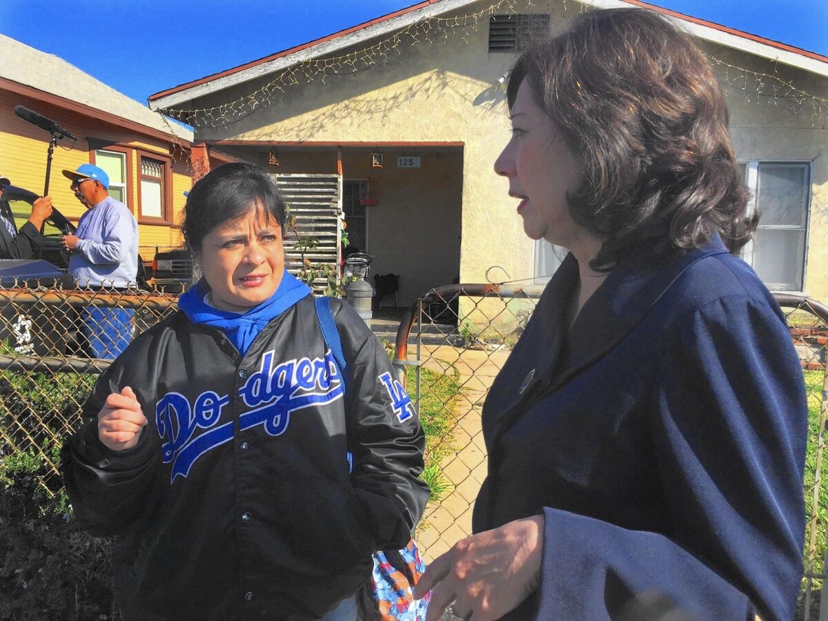 Amelia Vallejo talks to L.A. County Supervisor Hilda Solis about the lead contamination in her yard.