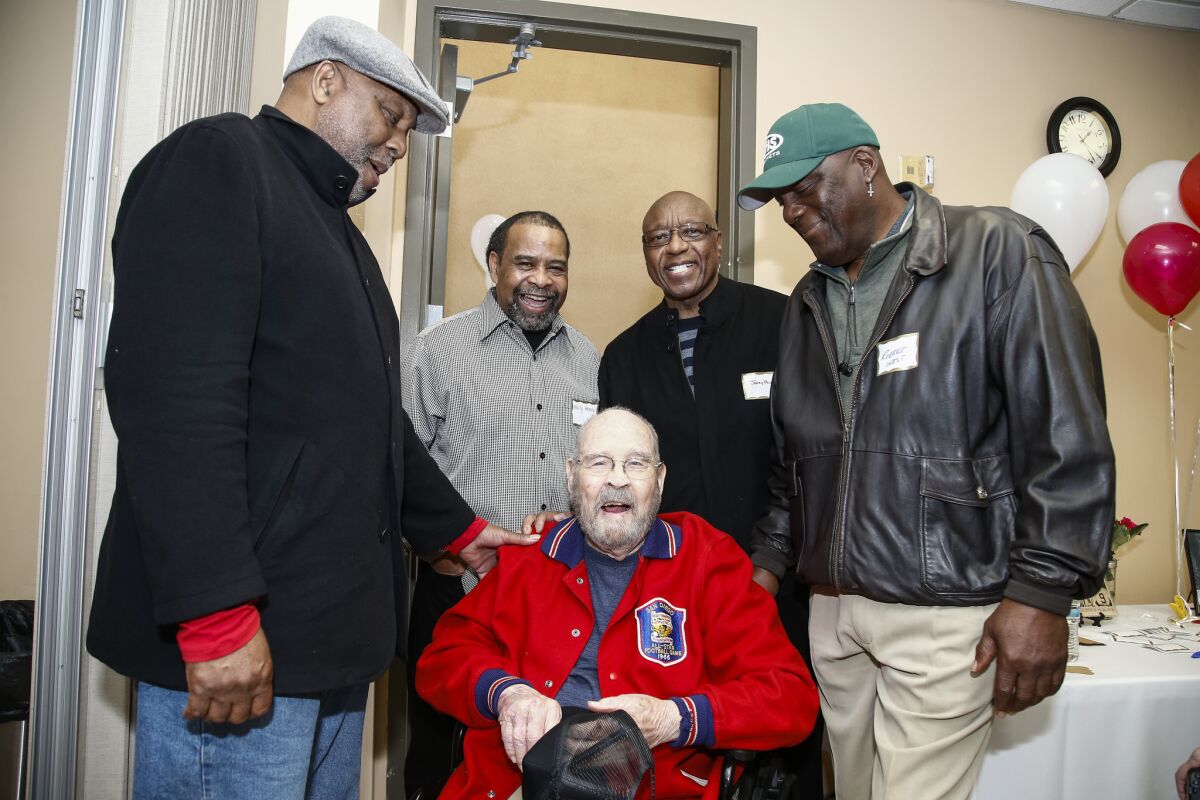 Coach Shan Deniston is greeted by former Lincoln players (left to right) Doug Jones, Wally Henry, Jerry Powell and Robert West last year at a celebration of Deniston's 100th birthday.