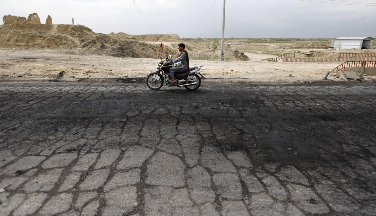 A man passes the site where a day earlier, on April 8, 2019, a suicide bombing attack killed three U.S. service members near Bagram Airfield, on the outskirts of Kabul, Afghanistan.