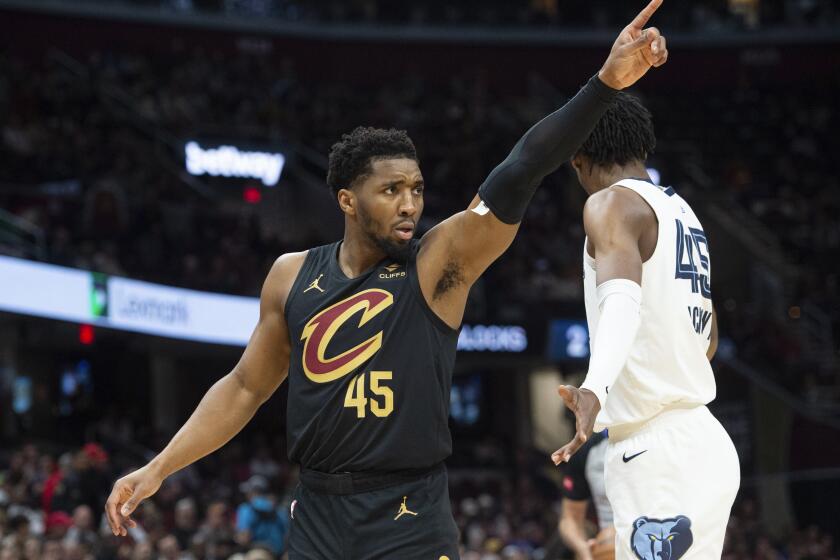 Cleveland Cavaliers' Donovan Mitchell (45) directs his team as Memphis Grizzlies' GG Jackson (45) stands by during the first half of an NBA basketball game in Cleveland, Wednesday, April 10, 2024. (AP Photo/Phil Long)