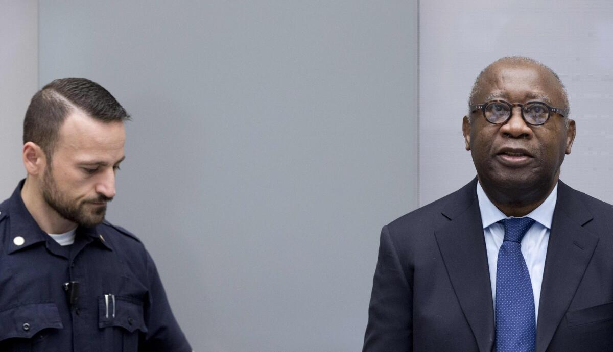 Former Ivory Coast President Laurent Gbagbo, right, arrives for the start of his trial at the International Criminal Court in The Hague.