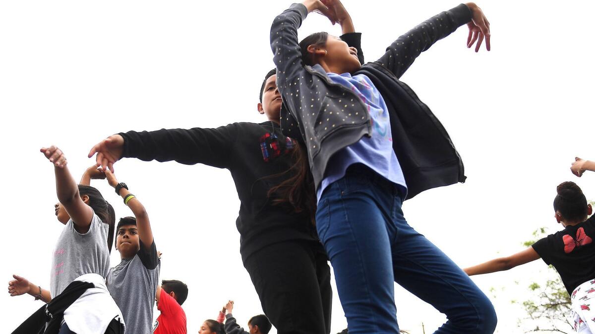 Mario Olivares and Jennifer Pec, center, fifth-graders at Estrella Elementary School in South Park, rehearse on their lunch break in preparation for the Conga Kids Dance Championship.