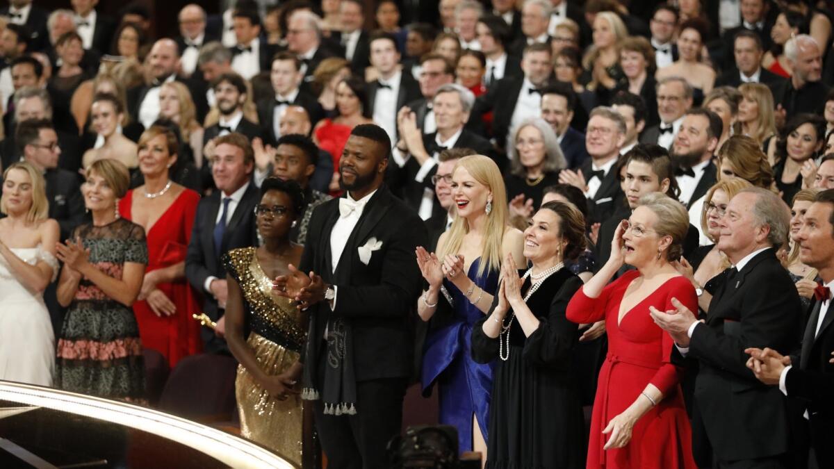 The audience stands for Faye Dunaway and Warren Beatty, presenters of the Oscar for best picture, during the Academy Awards ceremony at the Dolby Theatre on March 4.