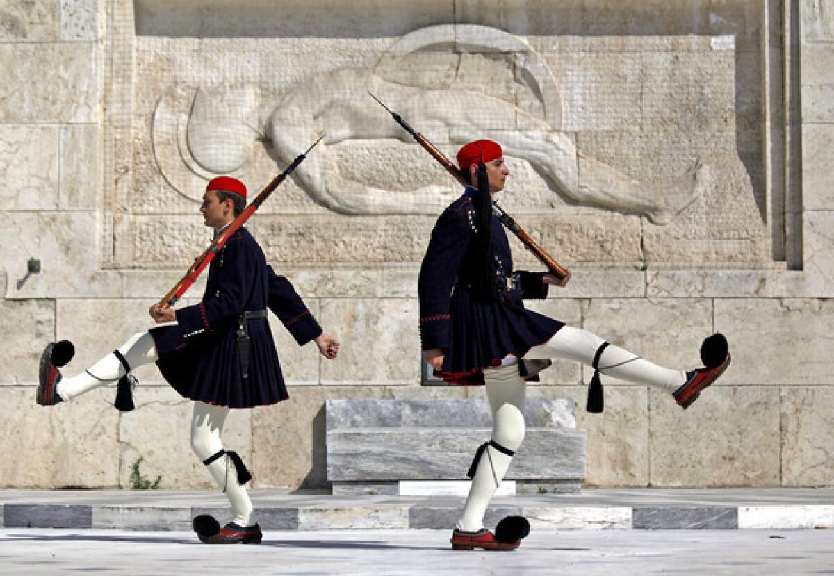 Greek presidential guards march at the monument of the unknown soldier in front of the parliament in Athens.