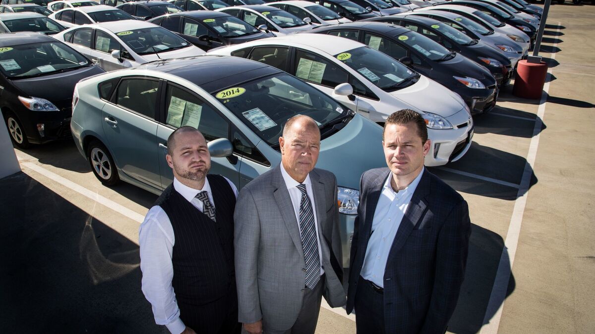 Toyota of Claremont refuses to sell these Priuses because, a lawsuit alleges, they have a defect that can cause the cars to lose power. Owner Roger Hogan, center, filed the suit.
