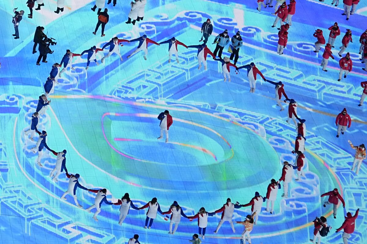 Athletes join hands in a ring at the 2022 Olympics.