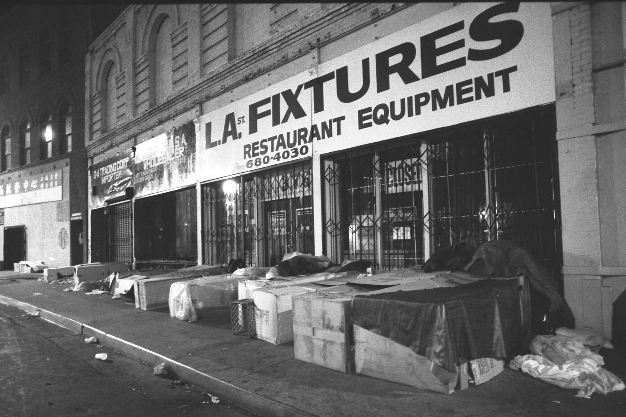 Homeless people sleep in boxes along storefronts in Los Angeles in 1987.