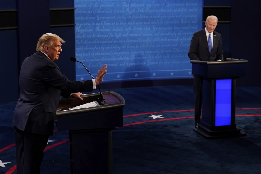 President Donald Trump answers a question as Democratic presidential candidate former Vice President Joe Biden listens during the second and final presidential debate Thursday, Oct. 22, 2020, at Belmont University in Nashville, Tenn. (AP Photo/Morry Gash, Pool)