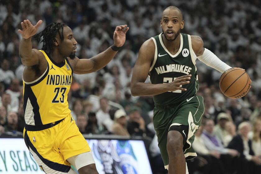Milwaukee Bucks' Khris Middleton gets past Indiana Pacers' Aaron Nesmith during the first half of Game 2 of the NBA playoff basketball game Tuesday, April 23, 2024, in Milwaukee. (AP Photo/Morry Gash)