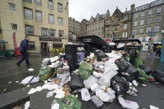 A view of overflowing bins in the Grassmarket area of Edinburgh where cleansing workers from the City of Edinburgh Council are on the fourth day of eleven of strike action, in Scotland, Wednesday, Aug. 24, 2022. Workers at waste and recycling depots across the city have rejected a formal pay offer of 3.5 percent from councils body Cosla. (Andrew Milligan/PA via AP)