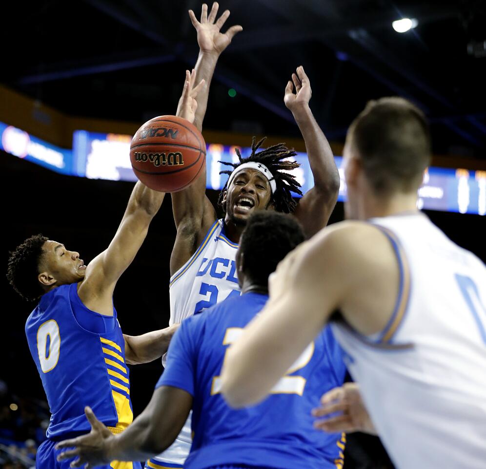 LOS ANGELES, CALIF. - NOV. 21, 2019. Bruins forward Jalen Hill dishes a pass off to teammate Alex Olesinski in the second half at Pauley Pavilion in Westwood on Thursday night, Nov. 21, 2019. (Luis Sinco/Los Angeles Times)