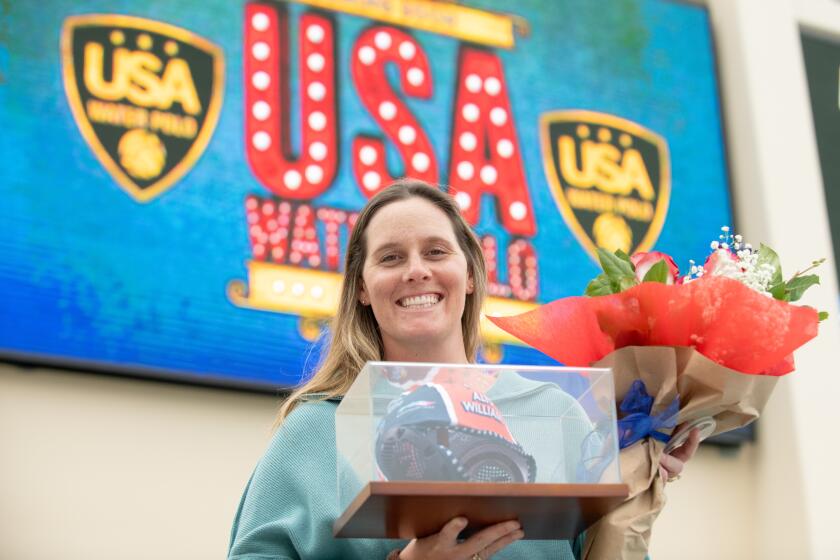 Gold medalist Alys Williams holds a cap and flowers given to her during a brief ceremony at Long Beach City College on Monday.