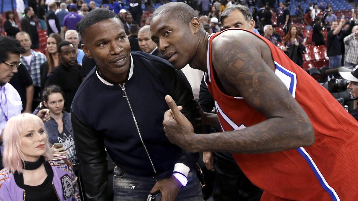 Guard Jamal Crawford chats with actor Jamie Foxx after the Clippers defeated the Kings, 111-104, on Wednesday night.