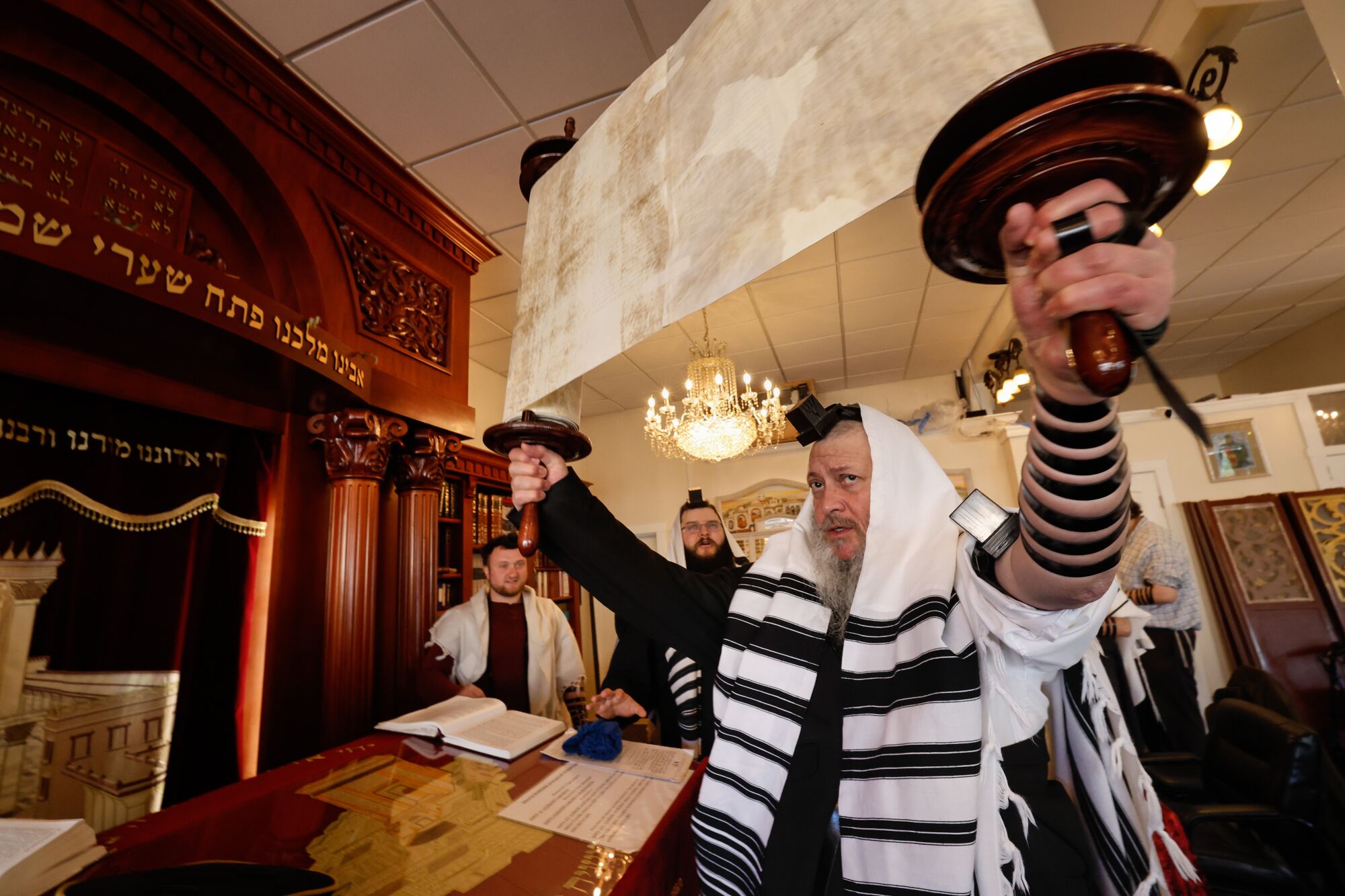 A rabbi raises the Torah at the Schneerson Jewish Center.