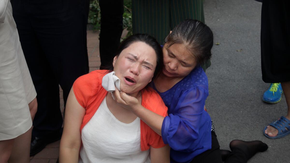 Fan Lili, left, the wife of imprisoned lawyer Gou Hongguo, cries as she is comforted after an incident with plainclothes police outside the Tianjin No. 2 Intermediate People's Court in Tianjin, China, on Aug. 1, 2016.