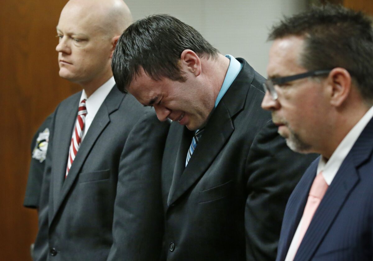 Daniel Holtzclaw, center, cries as he stands in front of the judge after the verdicts were read in his trial in Oklahoma City on Dec. 10, 2015. With Holtzclaw are defense attorneys Robert Gray, left, and Scott Adams, right.