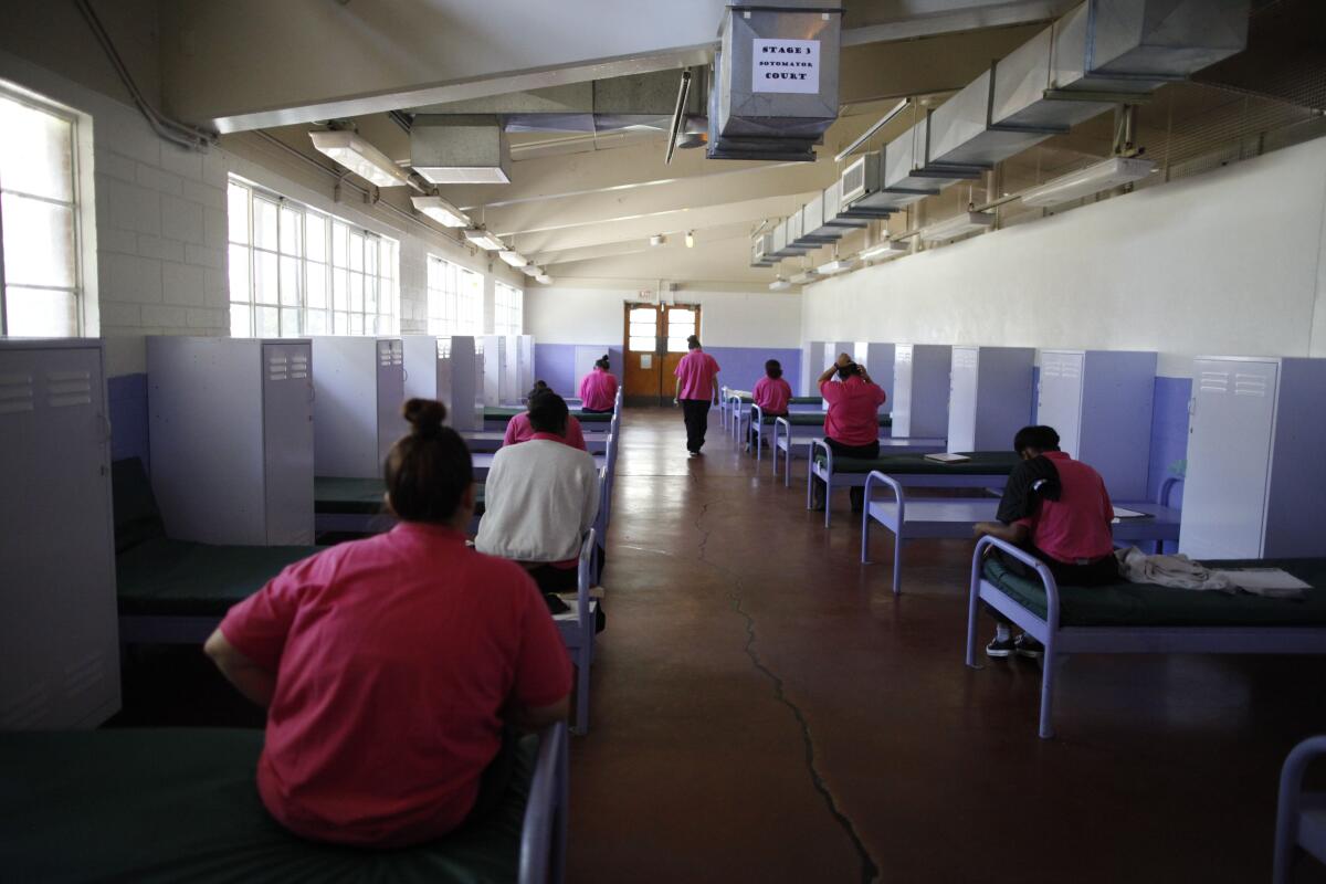 Camp Scott youth sit at attention on their beds and wait for movement instructions during lunch break. 