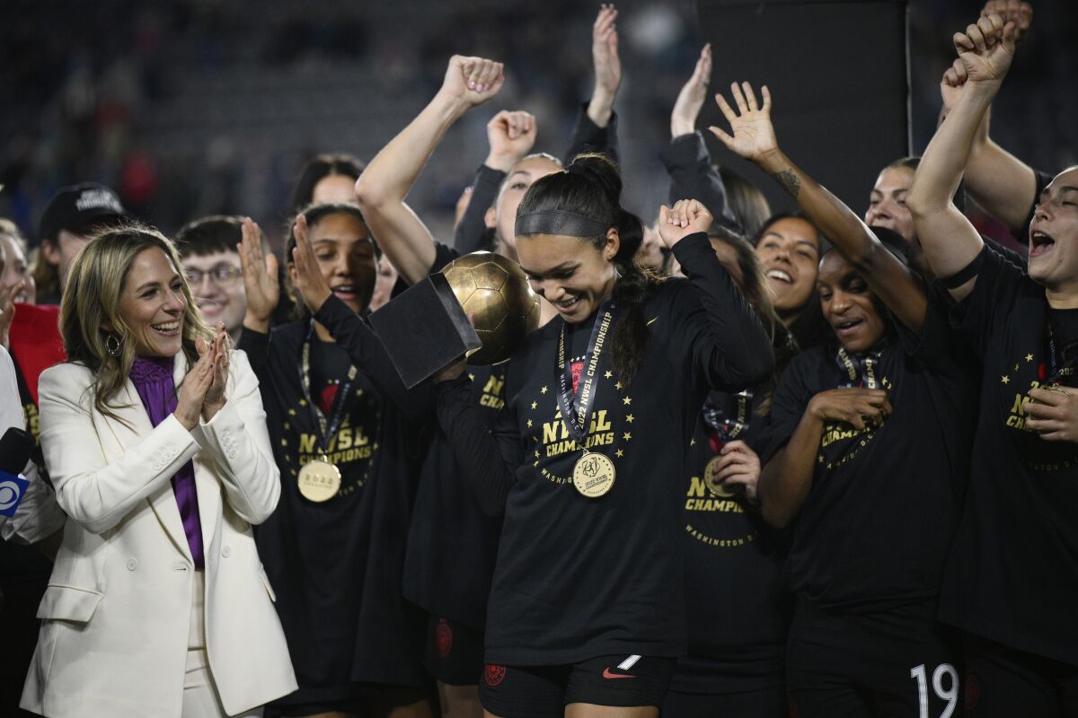FILE - Portland Thorns forward Sophia Smith holds the MVP trophy after the team's NWSL championship soccer match against the Kansas City Current, Oct. 29, 2022, in Washington. At left is NWSL Commissioner Jessica Berman. Portland is also among the favorites this season because of a loaded roster that includes U.S. national team players like Sophia Smith, Crystal Dunn and Becky Sauerbrunn. (AP Photo/Nick Wass, File)