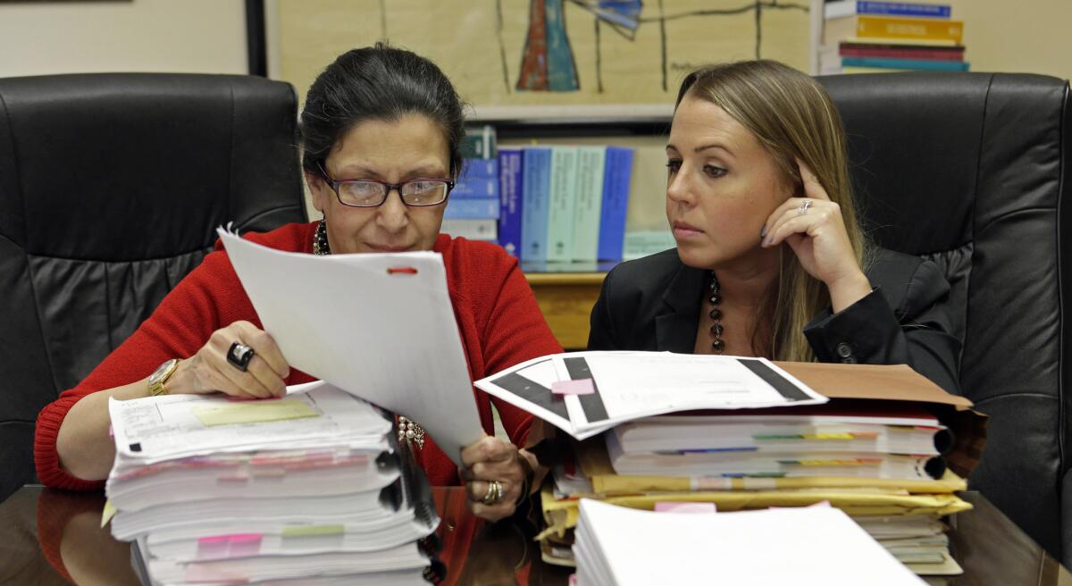 Fotografía del 16 de julio de 2015 de las abogadas Grisel Ybarra (izquierda) y Mónica Barba Neumann mientras revisan documentos en su oficina en Miami. Ybarra y Neumann representan a varios clientes que podrían ser deportados a Cuba. (Foto AP/Alan Díaz)