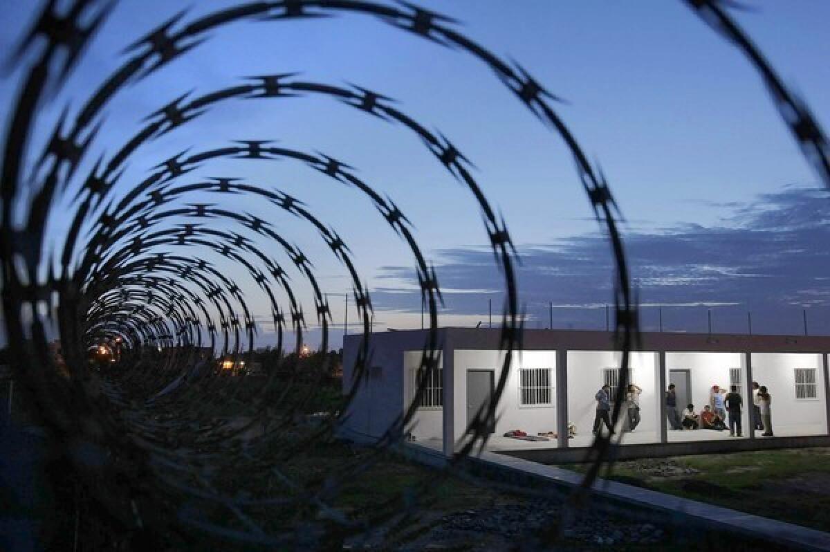 Razor wire tops the chain-link fence around a church-run migrant shelter in Matamoros, Mexico, where 15 deportees were dragged away at gunpoint Christmas Eve. Serafin Salazar, who had been an auto mechanic in El Monte, said, "I feel like something bad can happen at any time."