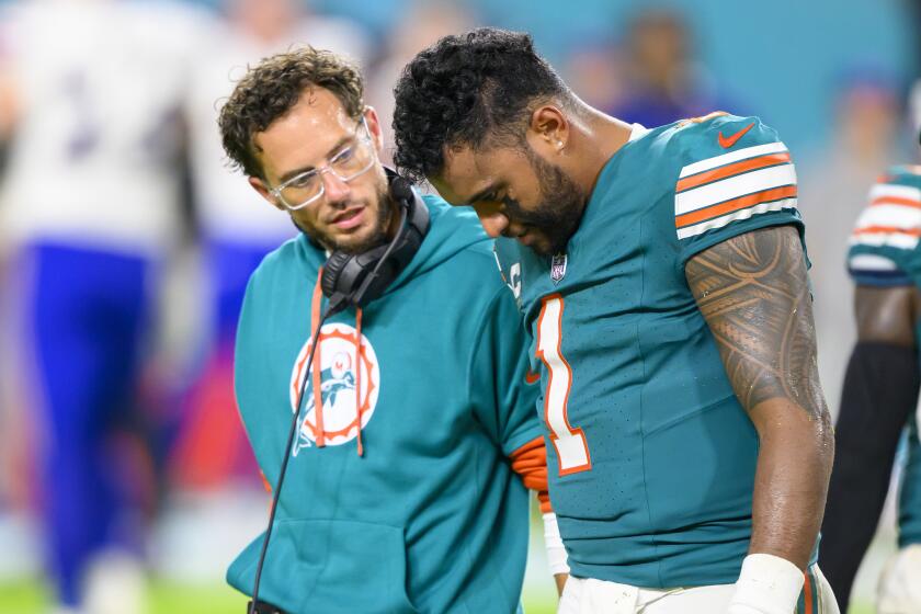 Miami Dolphins quarterback Tua Tagovailoa walks off of the field with head coach Mike McDaniel after suffering an injury