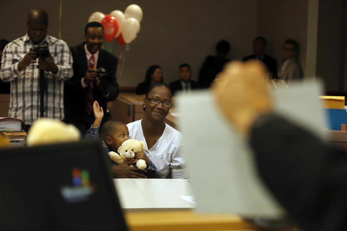 Judge Michael Nash holds a certificate indicating that Glenda Griffin is adopting little Tyus Jamell Griffin during proceedings at Edmund D. Edelman Children's Court.