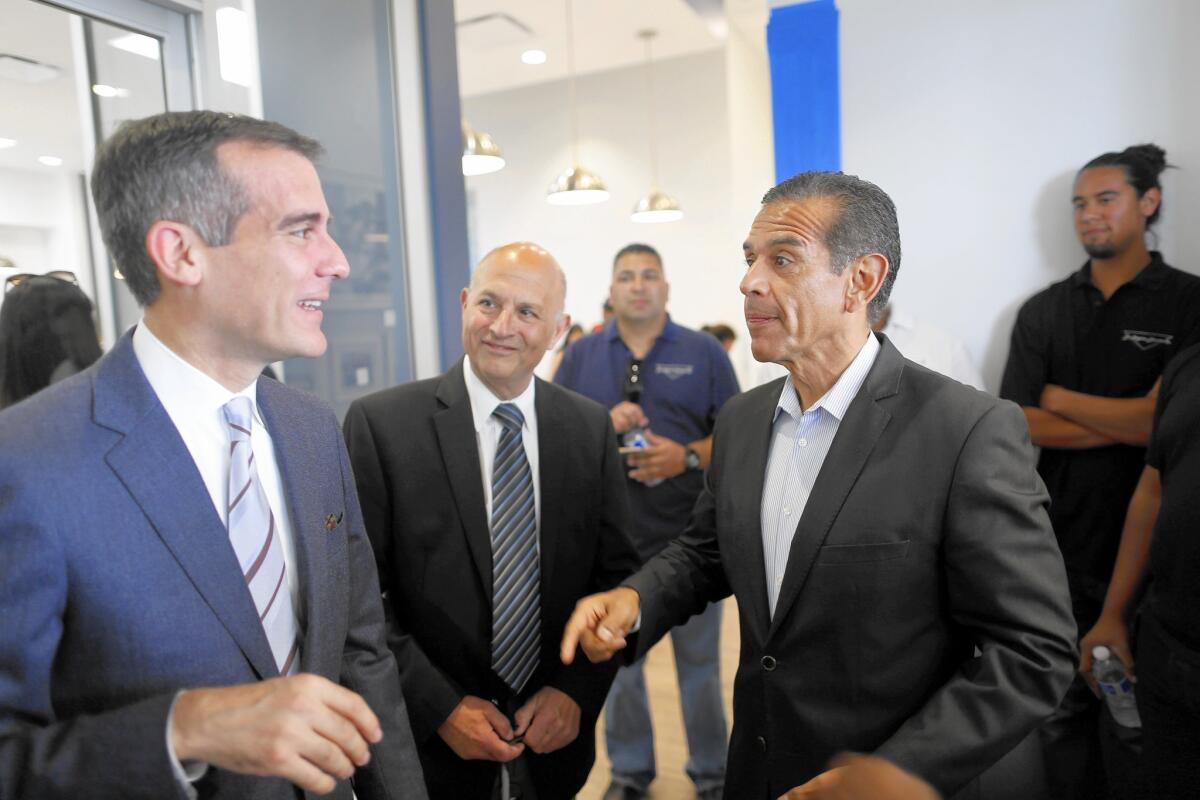 Among those at the ribbon-cutting ceremony marking the renovation of the Community Coalition's South L.A. headquarters were Mayor Eric Garcetti, left, and former Mayor Antonio Villaraigosa.