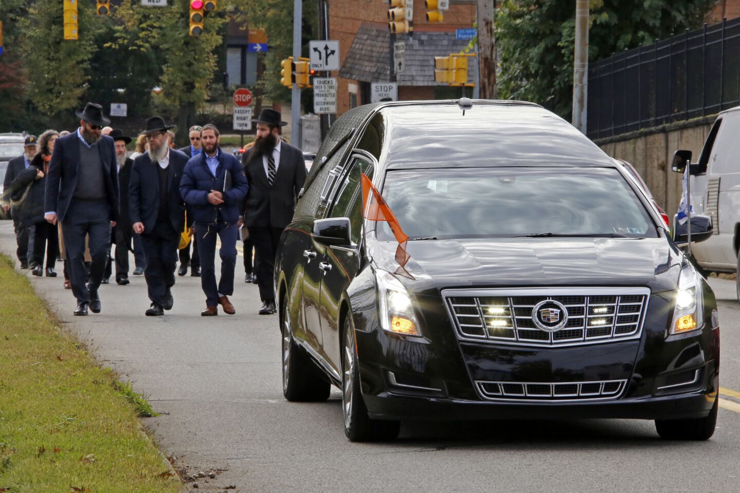 Mourners walk behind a hearse carrying the casket of Dr. Jerry Rabinowitz in Pittsburgh.