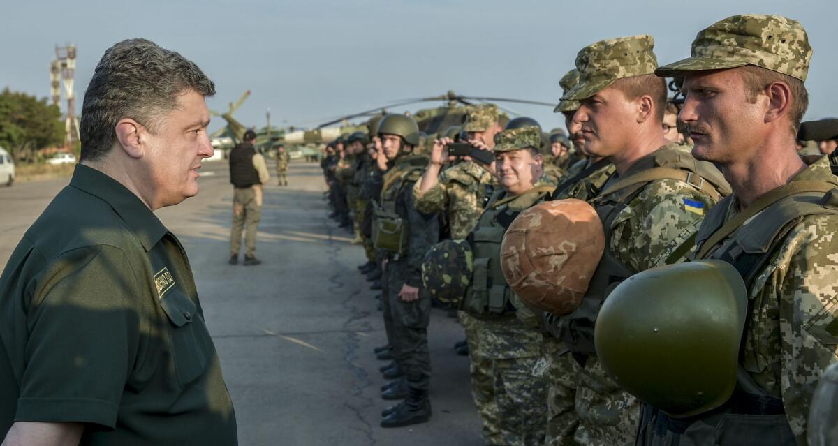 Ukrainian President Petro Poroshenko, left, inspects military personnel during his visit to the southeastern coastal town of Mariupol on Sept. 8.