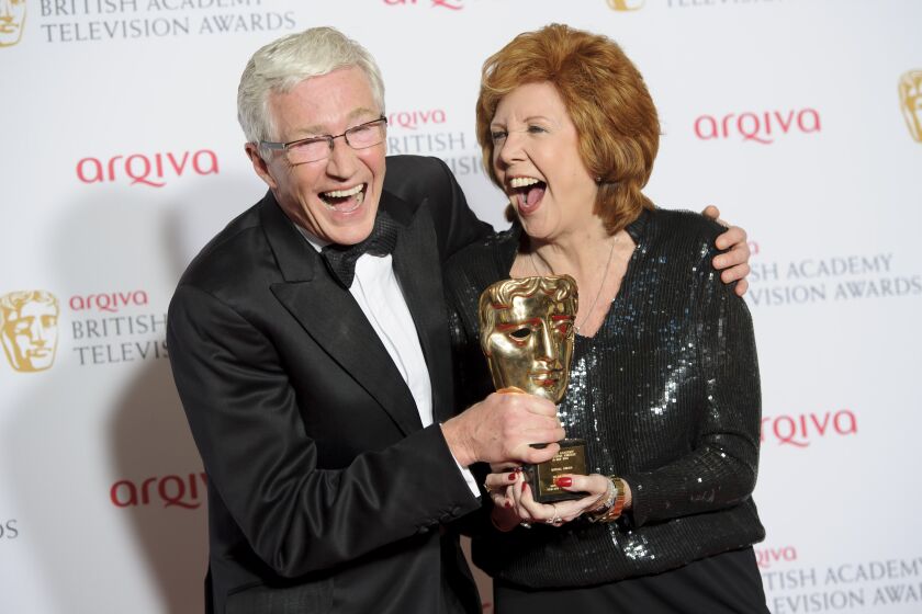 FILE - British presenters Paul O'Grady, left, and Cilla Black joke with her Special Award at the British Academy Television Awards at a central London venue, Sunday, May 18, 2014. Entertainer Paul O’Grady, who achieved fame as drag queen Lily Savage before becoming a much-loved comedian and host on British television, has died. He was 67. (Photo by Jonathan Short/Invision/AP, File)