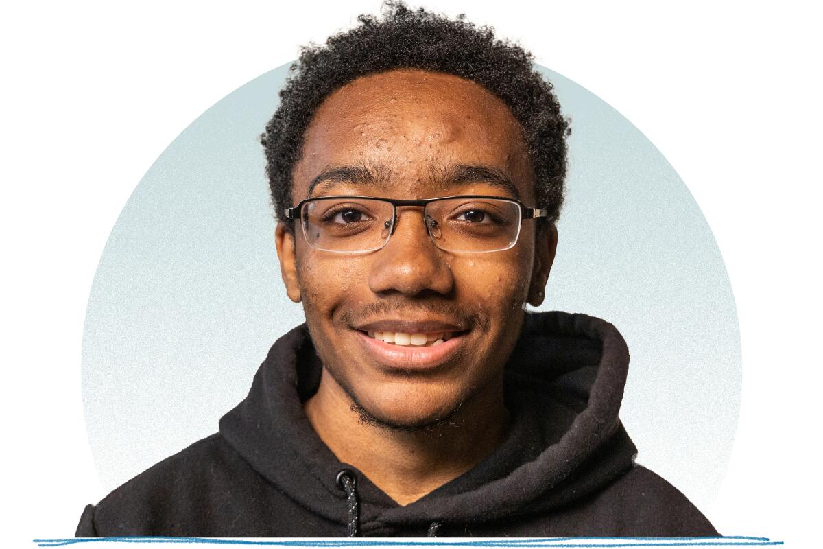 A smiling young man with short hair and glasses wearing a black hoodie.