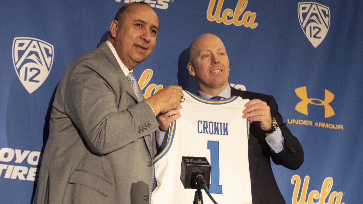 UCLA athletic director Dan Guerrero, left, welcomes new men's basketball coach Mick Cronin during Wednesday's news conference.