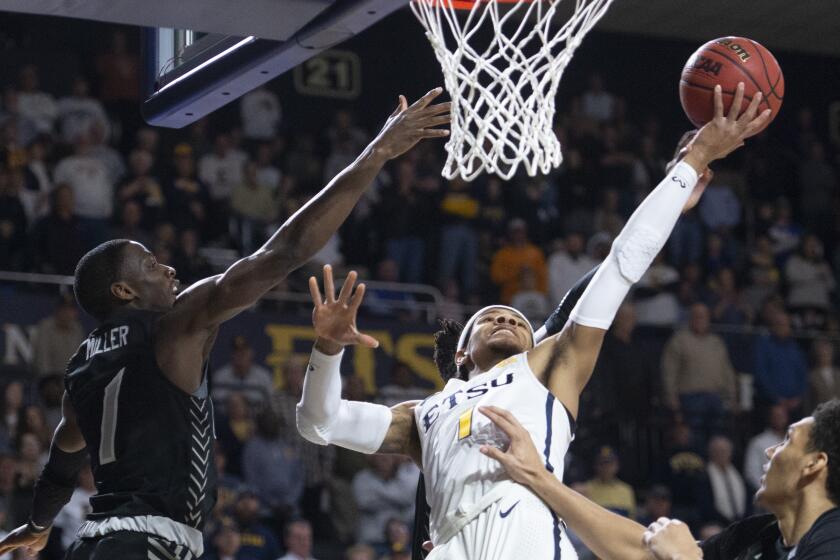 East Tennessee State's Tray Boyd III shoots against UNC Greensboro's Isaiah Miller an NCAA college basketball game Saturday, Feb. 1, 2020, in Johnson City, Tenn. (David Crigger/Bristol Herald Courier via AP)