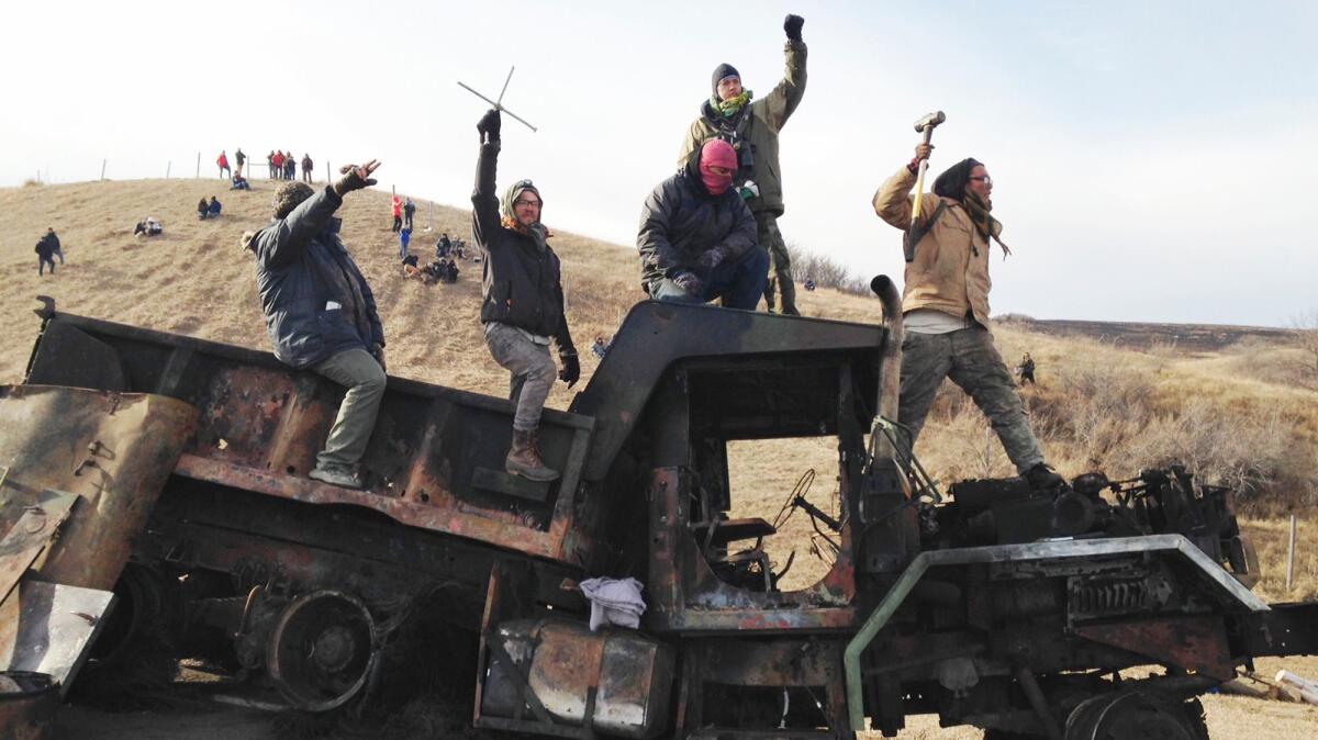 Protesters against the Dakota Access oil pipeline stand on a burned-out truck near Cannon Ball, N.D., on Nov. 21.