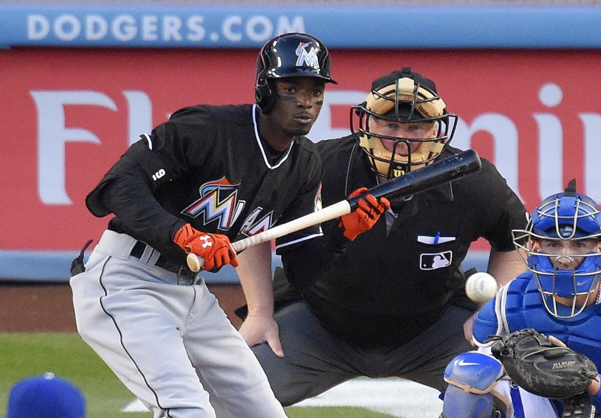 Miami's Dee Gordon bats in front of Dodgers catcher Yasmani Grandal and umpire Bill Miller at Dodger Stadium on April 28.