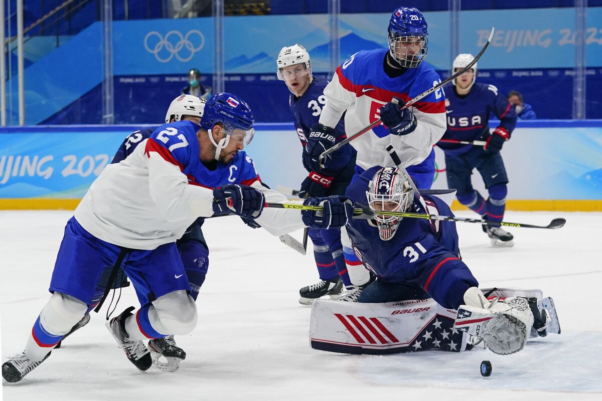 Slovakia and U.S. players battle in men's hockey at the 2022 Olympics.