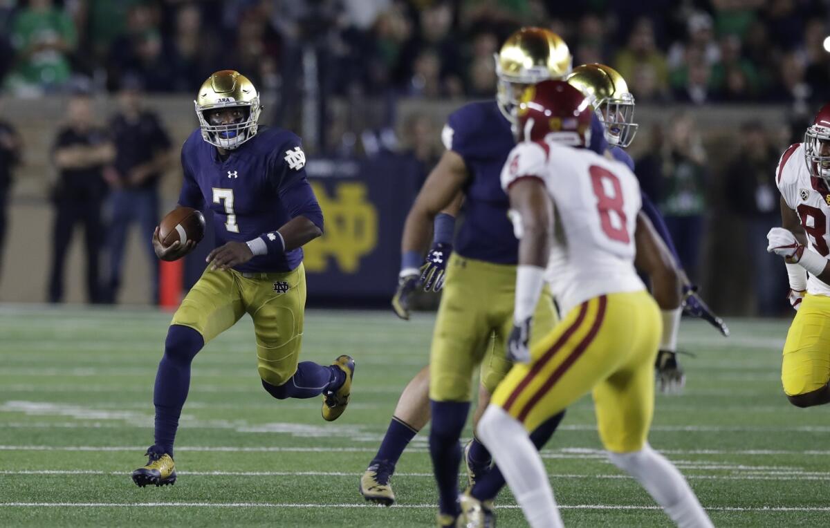 Notre Dame quarterback Brandon Wimbush is forced from the pocket by USC during the first half.