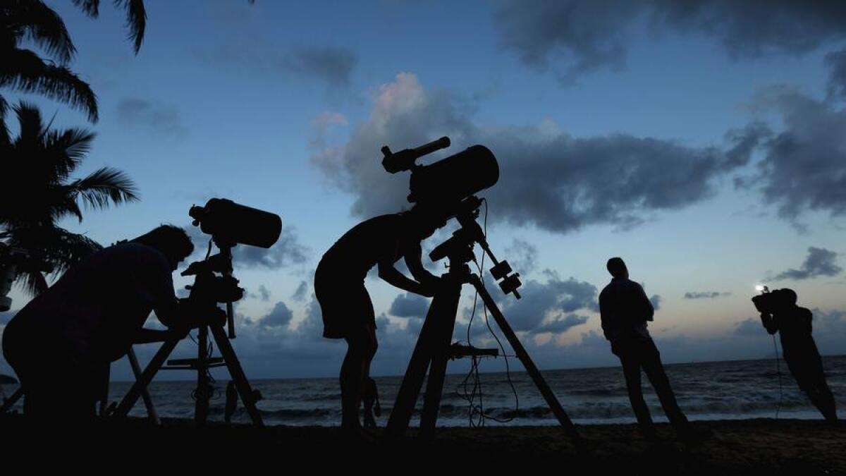 Cámaras telescópicas y equipos informáticos se instalan en Palm Cove Beach, en Australia, en preparación para un eclipse total de sol ocurrido en 2012 ().