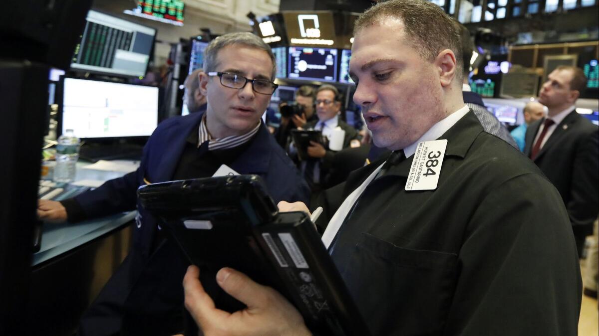 Specialist Anthony Rinaldi, left, and trader Robert Gasparino work on the floor of the New York Stock Exchange on Jan. 18.